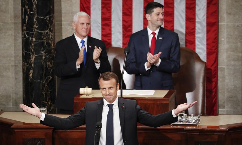 French President Emmanuel Macron gestures as he is introduced before speaking at a joint meeting of Congress on Capitol Hill in Washington, Wednesday, April 25, 2018. Standing behind him are Vice President Mike Pence and House Speaker Paul Ryan of Wis. 