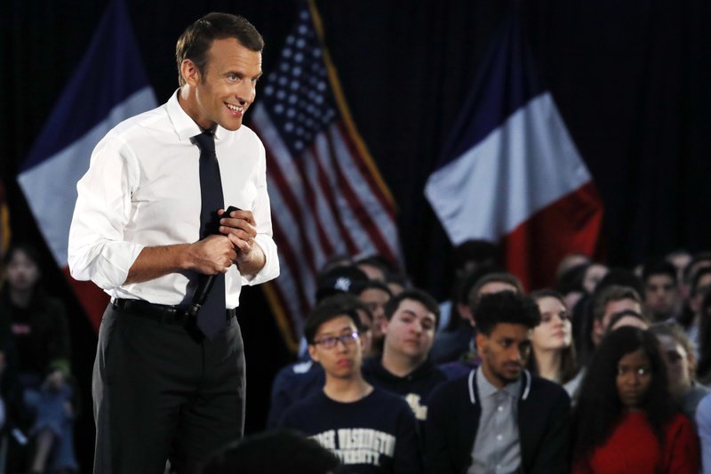 French President Emmanuel Macron smiles as he listens to a question in French from a student at George Washington University, Wednesday April 25, 2018, in Washington. 