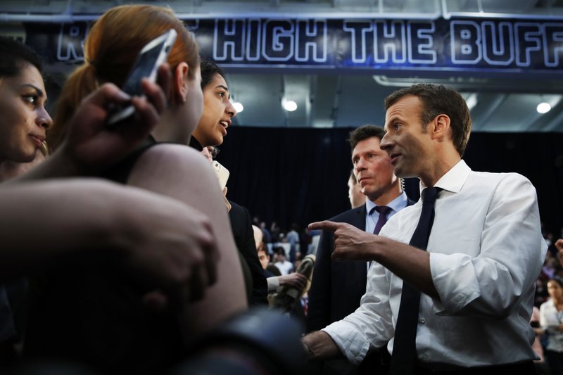 French President Emmanuel Macron, right, shakes hands after speaking to students at George Washington University, Wednesday, April 25, 2018, in Washington