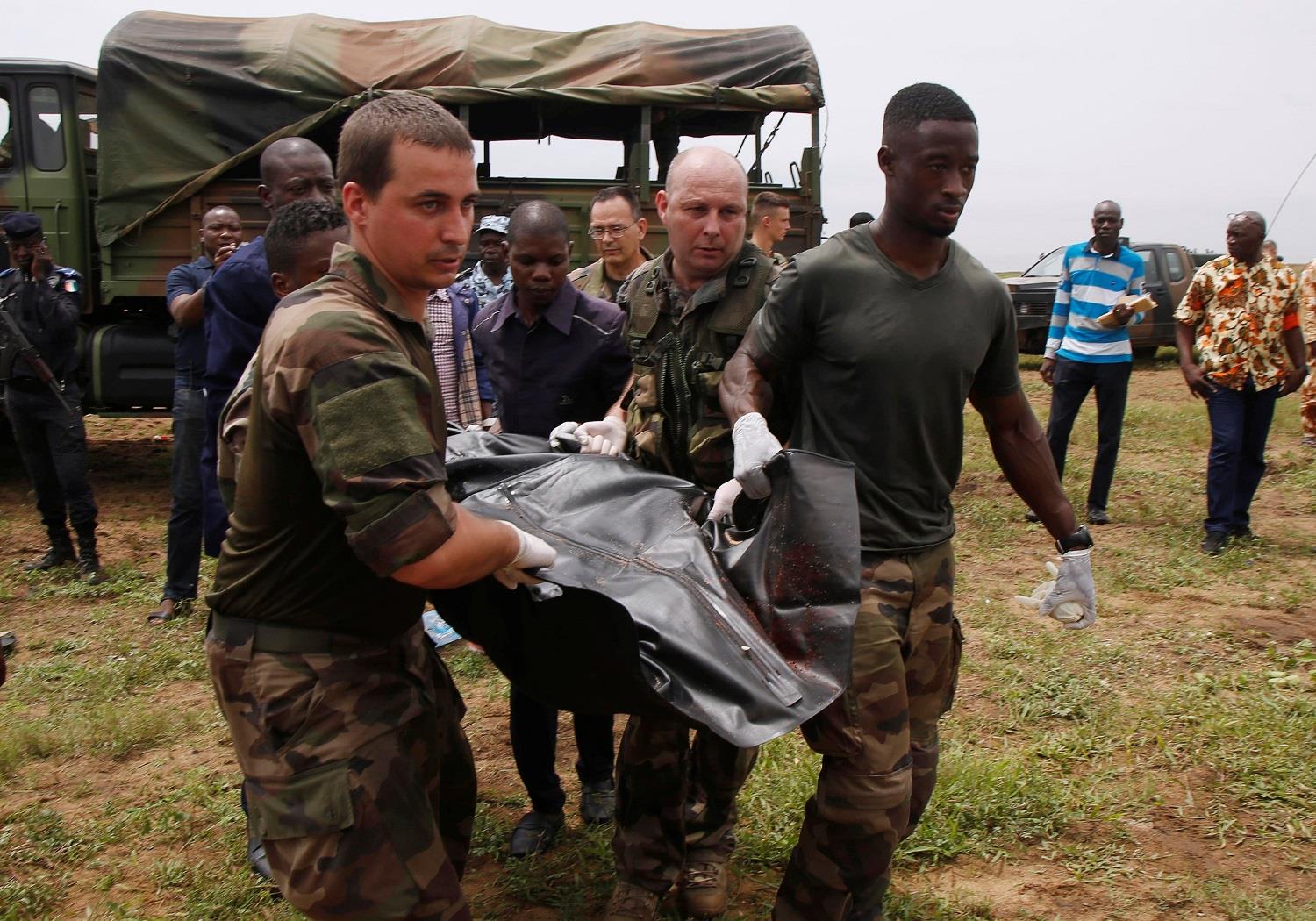 French soldiers and rescuers carry a body after a propeller-engine cargo plane crashed into the sea near the international airport in Ivory Coast’s main city, Abidjan.