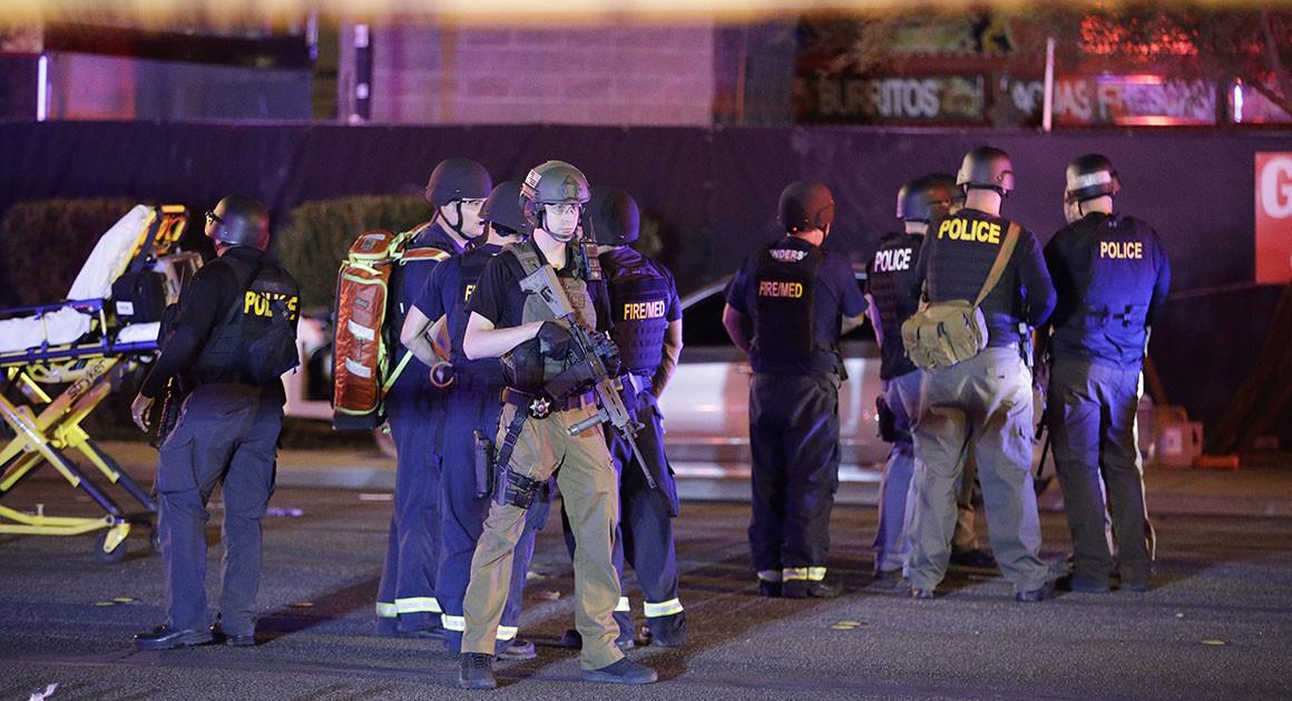 Police officers and medical personnel stand at the scene of a shooting near the Mandalay Bay resort and casino on the Las Vegas Strip on Monday in Las Vegas