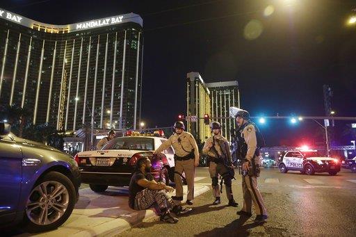 Police officers stand at the scene of a shooting near the Mandalay Bay resort and casino on the Las Vegas Strip, Sunday, Oct. 1, 2017, in Las Vegas.