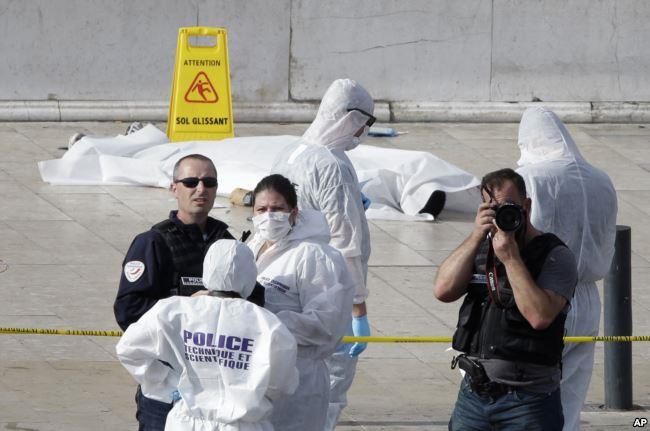 Police officers investigate by a body covered with white sheet outside Marseille's main train station