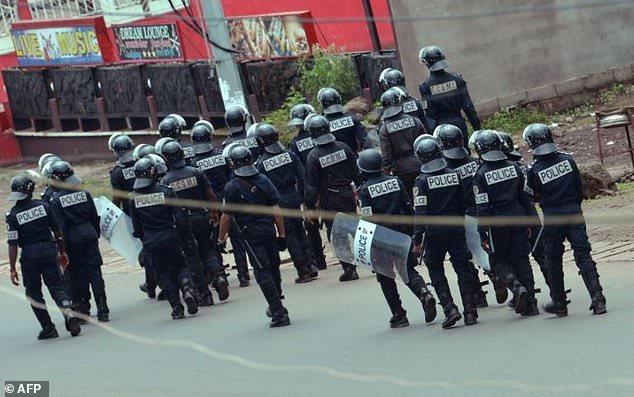 Cameroon police officials walk with riot shields on a street in the administrative quarter of Buea