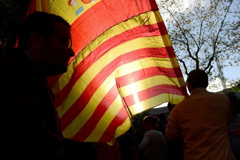 A protester waves the Spanish and Catalan flags together