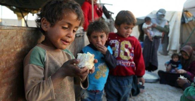A Syrian child holds a piece of cauliflower at the Ash'ari camp for the displaced in rebel-held eastern Ghouta outside Damascus on October 25, 2017
