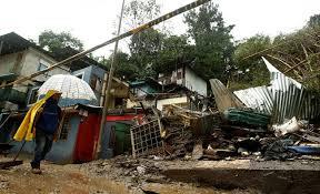 A man walks near houses damaged by a mudslide during heavy rains of Tropical Storm Nate that affects the country in San Jose, Costa Rica on Friday 