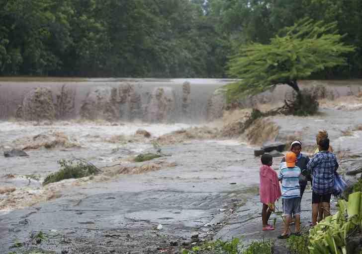 Residents look at the floodings of the Masachapa River following the passage of Tropical Storm Nate in the city of Masachapa