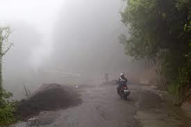 Neighbors walk under the rain past a washed out road in Alajuelita on the outskirts of San Jose