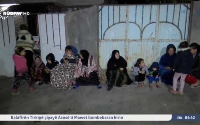 People sit on the pavement after an earthquake at an unknown location in Iraq in this still image taken from video Nov 13, 2017. Rudaw TV