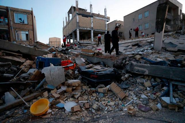 In this photo, people look at destroyed buildings after an earthquake at the city of Sarpol-e-Zahab in western Iran