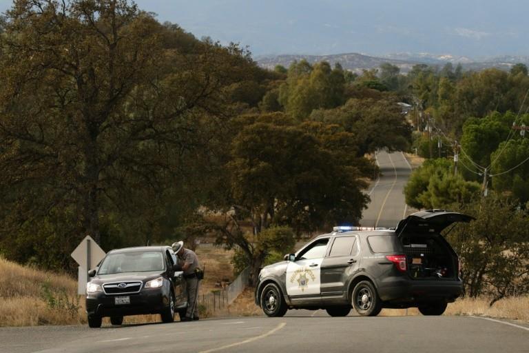  A Highway Patrol officer speaks to a woman at a road block after a shooting on November 14, 2017, in Rancho Tehama, California