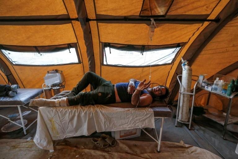  An Iranian quake victim lies on an operating bed after receiving treatment at a field hospital in the town of Sar-e Pol-e Zahab