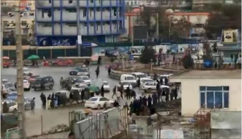 People in the street stand outside a building affected by explosion after a suicide bomb blast in Kabul, Afghanistan, November 16, 2017, in this still image from a social media video.