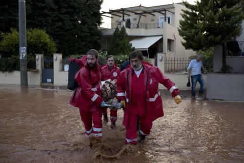 A team Of firemens carry an elderly man to the ambulance in the municipality of Mandra western Athens, on Wednesday, Nov. 15, 2017