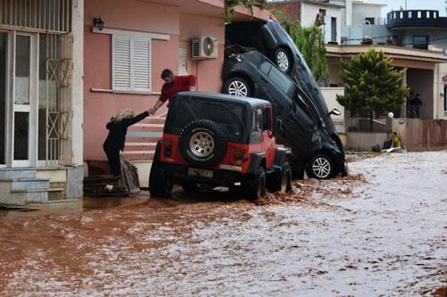 A man helps evacuate a woman from a flooded street in Mandra, northwest of Athens, on November 16, 2017.