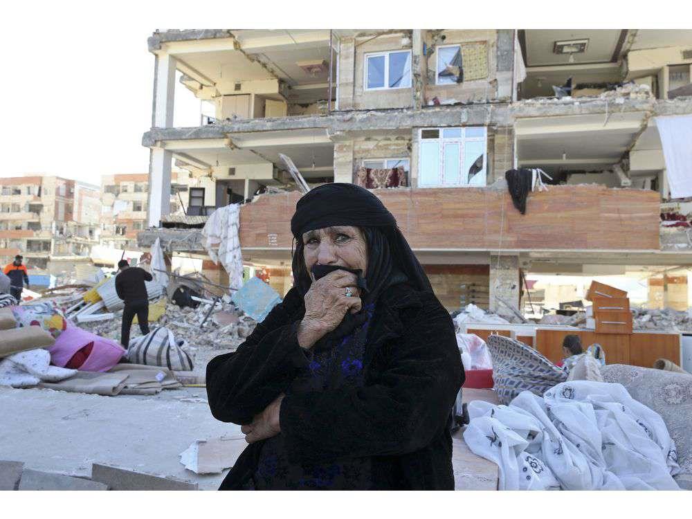 An earthquake survivor weeps as she sits in front of damaged buildings, in a compound which was built under the Mehr state-owned program, in Sarpol-e-Zahab in western Iran, Tuesday, Nov. 14, 2017. 