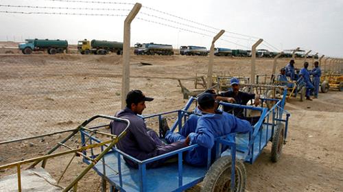 Iraqi porters sit on their carts as they wait for customers overlooking Iran bound oil tankers at the new Zurbatia checkpoint, 120 km southeast of Baghdad November 17, 2007. 