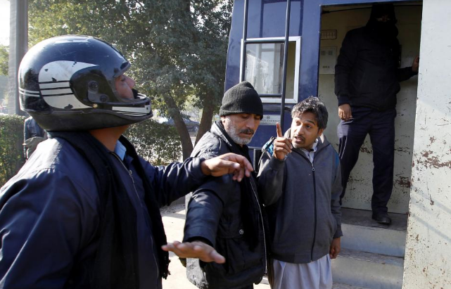 A demostrator detained by police gestures after being hit by a policeman as he is led to a police van near the Faizabad junction in Islamabad, Pakistan November 25, 2017
