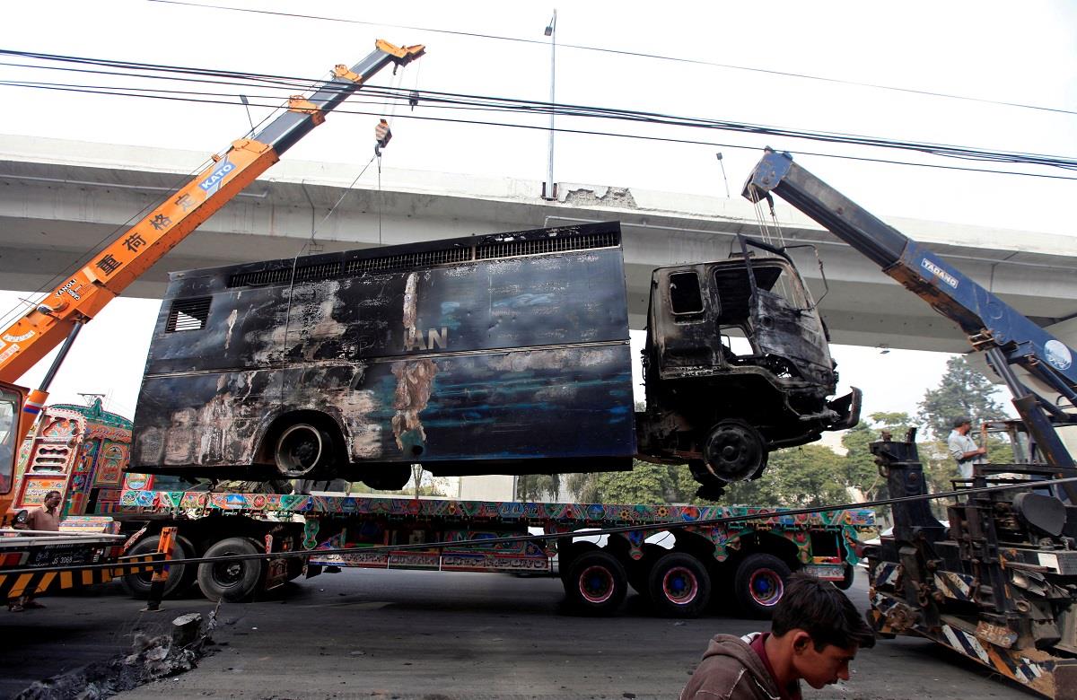 A police prison van, destroyed during clashes, is cleared from the road a day after the Tehreek-e-Labaik Pakistan Islamist political party called off nationwide protests in Islamabad.