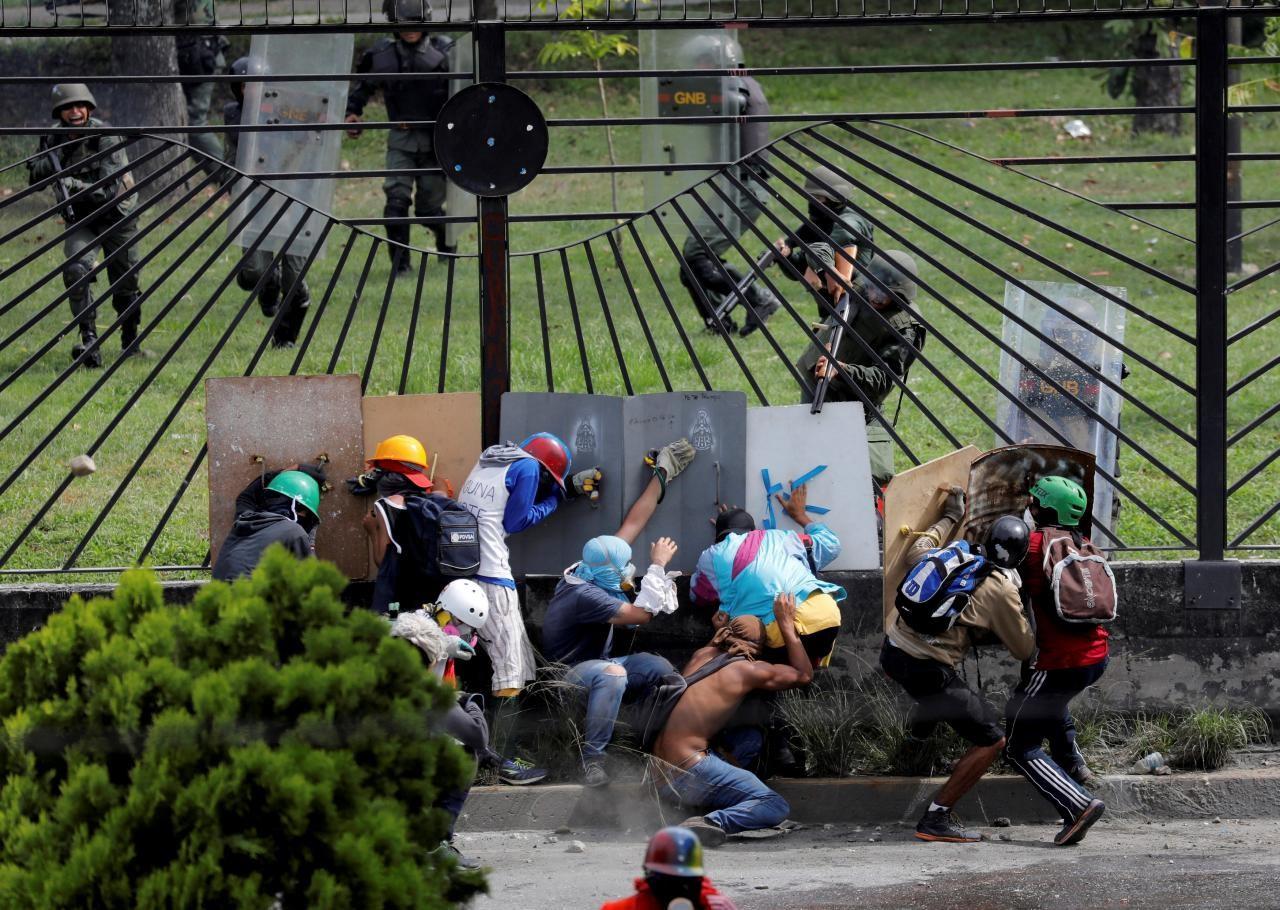Demonstrators clash with riot security forces at the fence of an air base while rallying against Venezuela's President Nicolas Maduro in Caracas, Venezuela, May 31, 2017.
