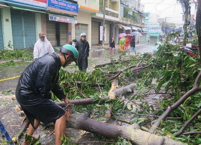 Residents were forced to wade through knee-deep floodwaters, as toppled electricity poles and trees blocked roads