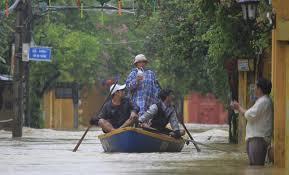 People ride a boat in flooded street in Hoi An, Vietnam, Monday, Nov. 6, 2017.