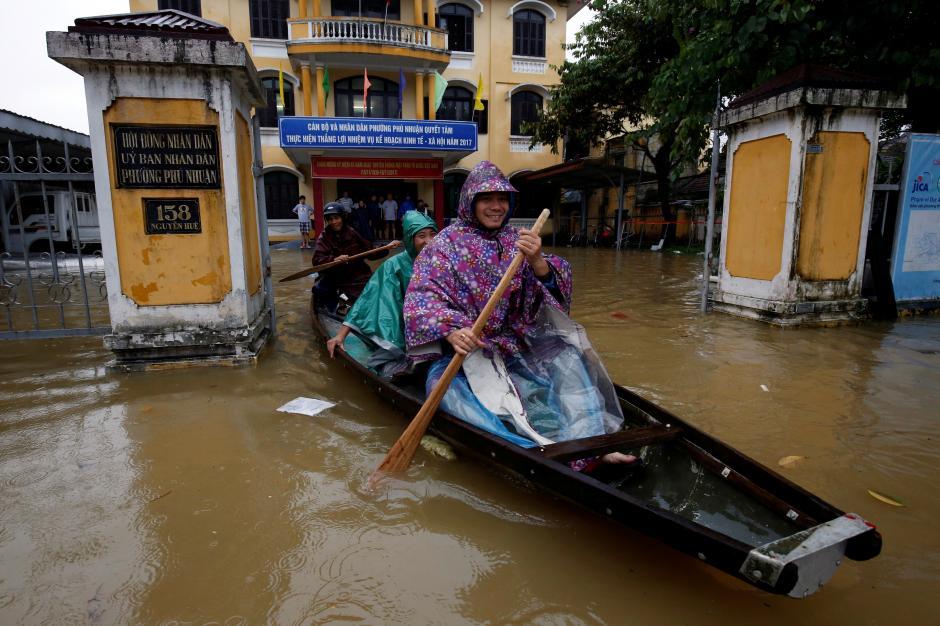 Officials sail a boat out of a submerged local government building in Hue. 