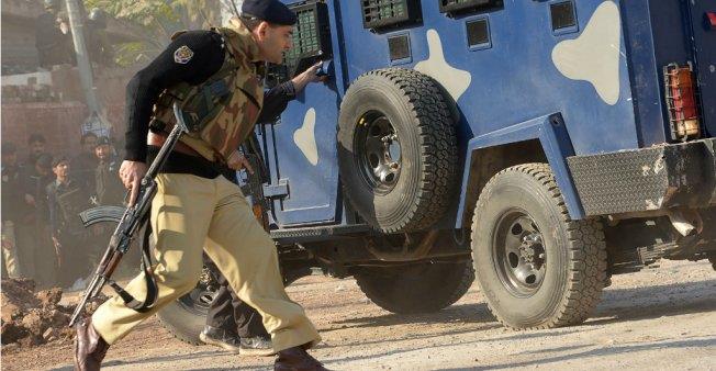 Pakistani security personnel take position outside an Agriculture Training Institute after an attack by Taliban militants in Peshawar on December 1, 2017.