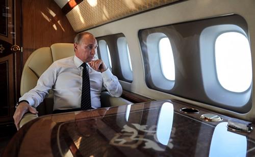 President Putin looks through the porthole while aboard the presidential plane during the approach to the Russian air base in Hmeimim on December 11, 2017.