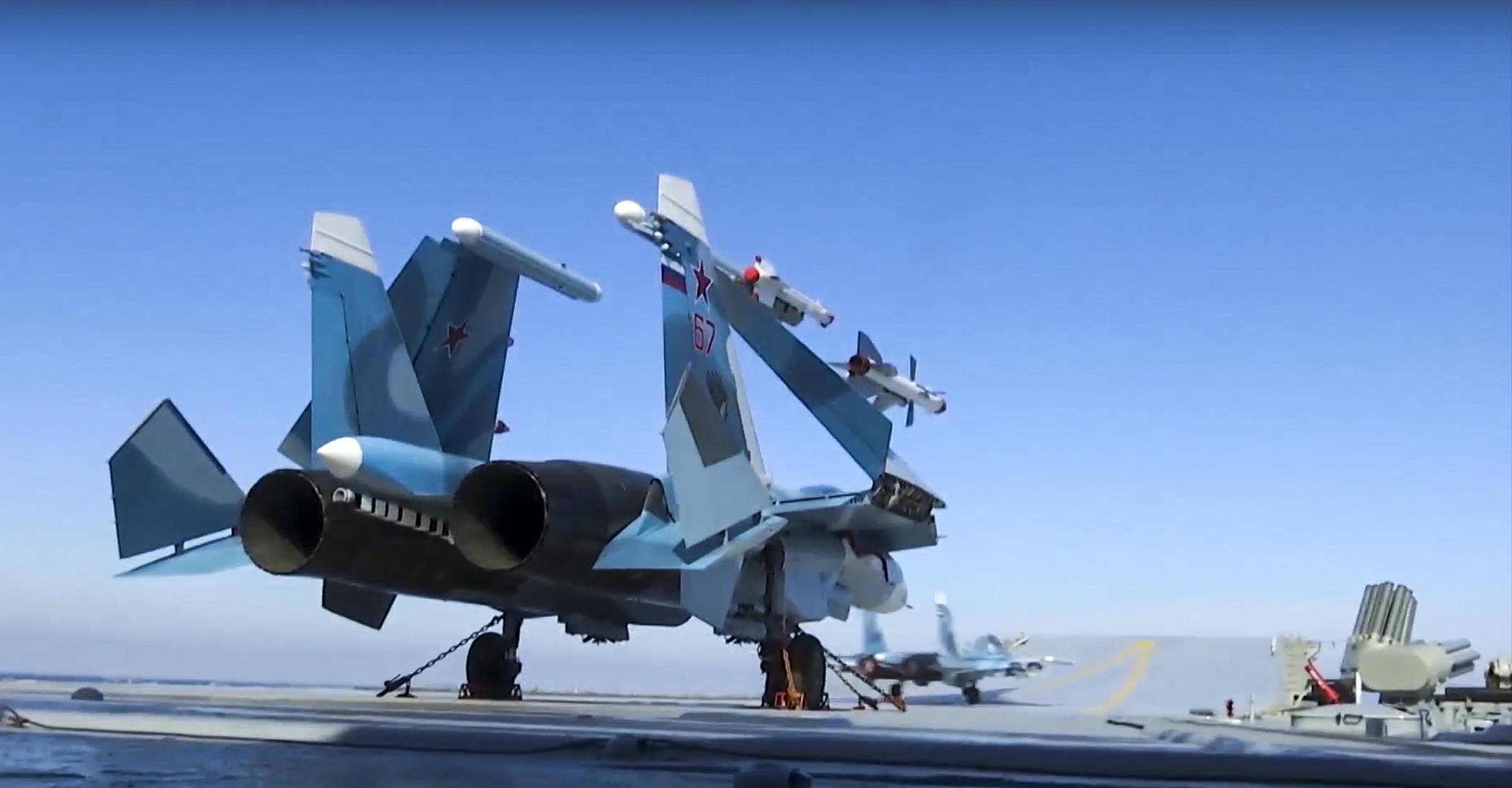 In this photo made from the footage taken from Russian Defense Ministry on Nov. 15, 2016, Russian Su-33 fighter jets are parked on the flight deck of the Admiral Kuznetsov aircraft carrier in the eastern Mediterranean Sea
