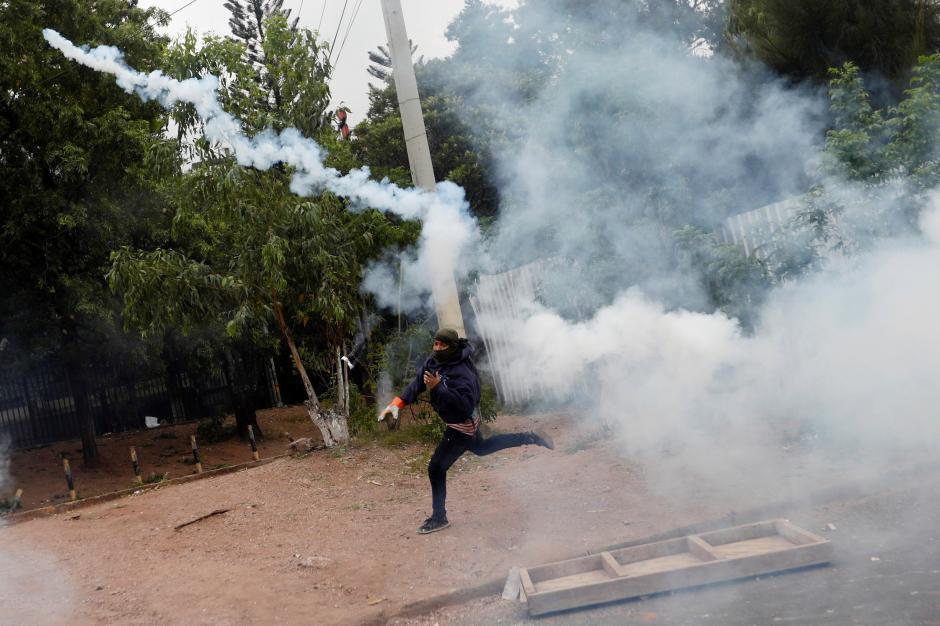  Opposition Alliance Against the Dictatorship throws a tear gas canister during a clash with riot police as they wait for official presidential election