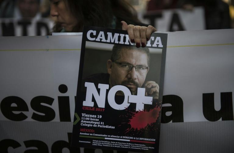 Chilean journalists hold signs condemning violence against journalists while protesting the recent murder of Mexican journalist Javier Valdez