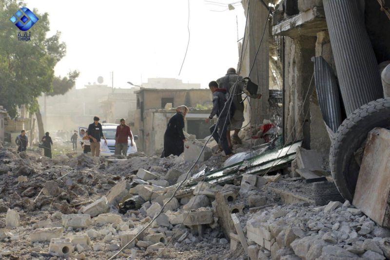 This image released by Thiqa News Agency shows people inspecting damage from airstrikes on a market