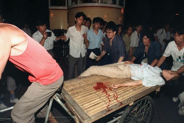 A girl wounded during clashes between the army and students near Tiananmen Square being carried out on a cart