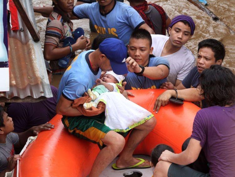 Image: Policemen evacuate a baby in Cagayan City