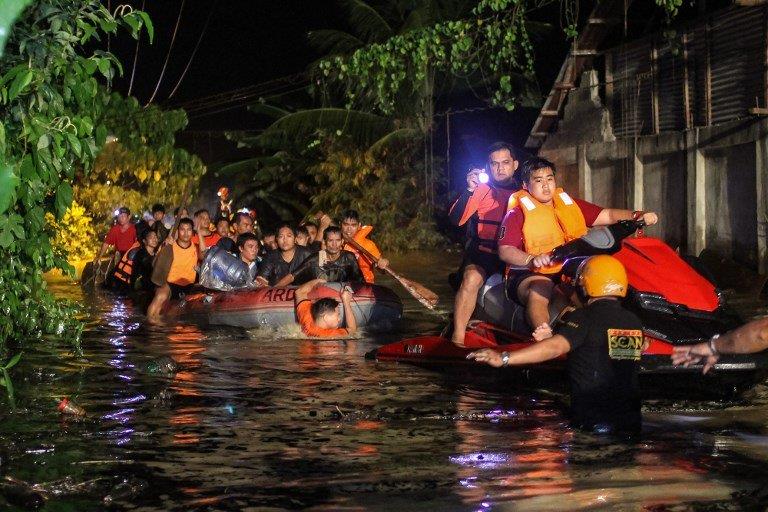 Rescue workers evacuate flood-affected residents in Davao on the southern Philippine island of Mindanao early on December 23, 2017, after Tropical Storm Tembin dumped torrential rains across the island. The death toll from the tropical storm that struck the southern Philippines has risen to 30 with five others missing, officials said on December 23 