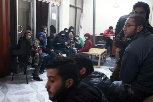 Civilians wait during an evacuation operation by the International Committee of the Red Cross in Douma in the eastern Ghouta region on the outskirts of the Damascus, Syria.
