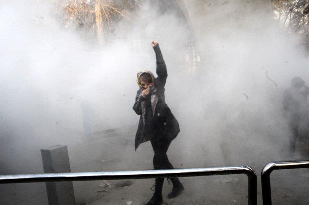 DEFIANCE: Tehran university Student protests stand against riot police hurling tear gas at them in Tehran