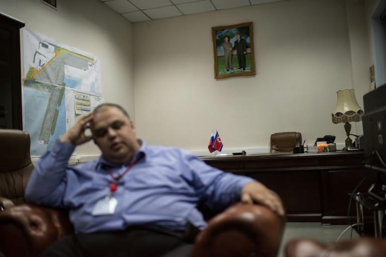 RasonConTrans deputy director Roman Minkevich in his office which sports a picture of Vladimir Putin and late North Korean leader Kim Jong-Il shaking hands