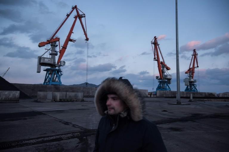 A Russian worker walking before cranes at Rajin's RasonConTrans coal port in North Korea