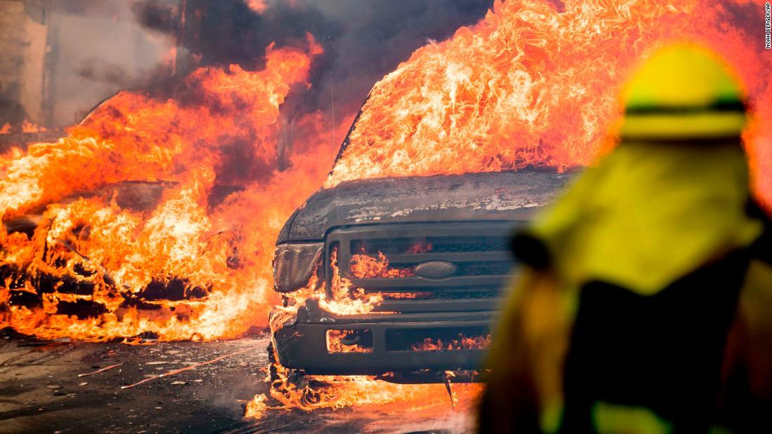  Flames consume vehicles in Ventura on Tuesday, December 5, as wildfires spread in Southern