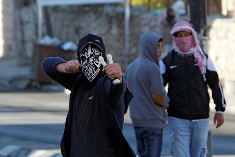 A Palestinian protester launches a slingshot at Israeli troops manning a checkpoint in the West Bank town of Bethlehem on December 9, 2017