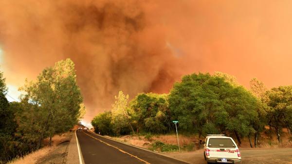 A plume of smoke rises as flames from the Wall fire burn near Oroville, Calif.