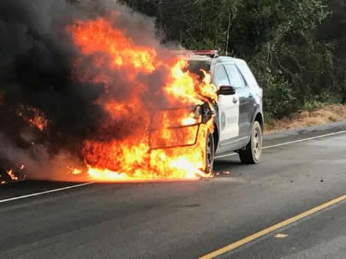 A police vehicle parked on Highway 154 is engulfed by flames of the Whittier wildfire near Santa Ynez, California, U.S. July 9, 2017