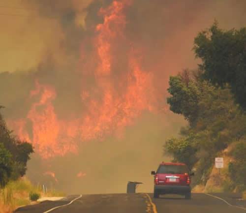 A Santa Barbara City Fire vehicle drives on Highway 154 towards flames from the Whittier Fire east of Cachuma Lake near Santa Barbara, California, U.S. in this July 8, 2017,