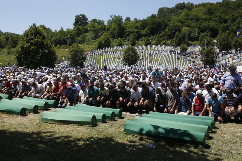 Bosnian Muslim people pray in front of coffins during a funeral ceremony for dozens of newly identified victims of the 1995 massacre, at the memorial centre of Potocari near Srebrenica, 150 kms north east of Sarajevo, Bosnia, Tuesday, July 11, 2017.