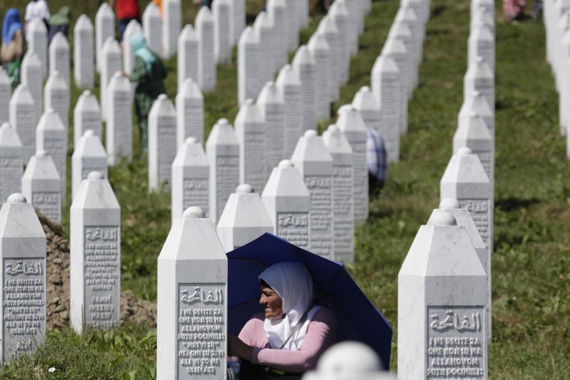 A Bosnian Muslim woman protects herself from the sun during a funeral ceremony for dozens of newly identified victims of the 1995 massacre, at the memorial centre of Potocari near Srebrenica, 150 kms north east of Sarajevo, Bosnia, Tuesday, July 11, 2017.