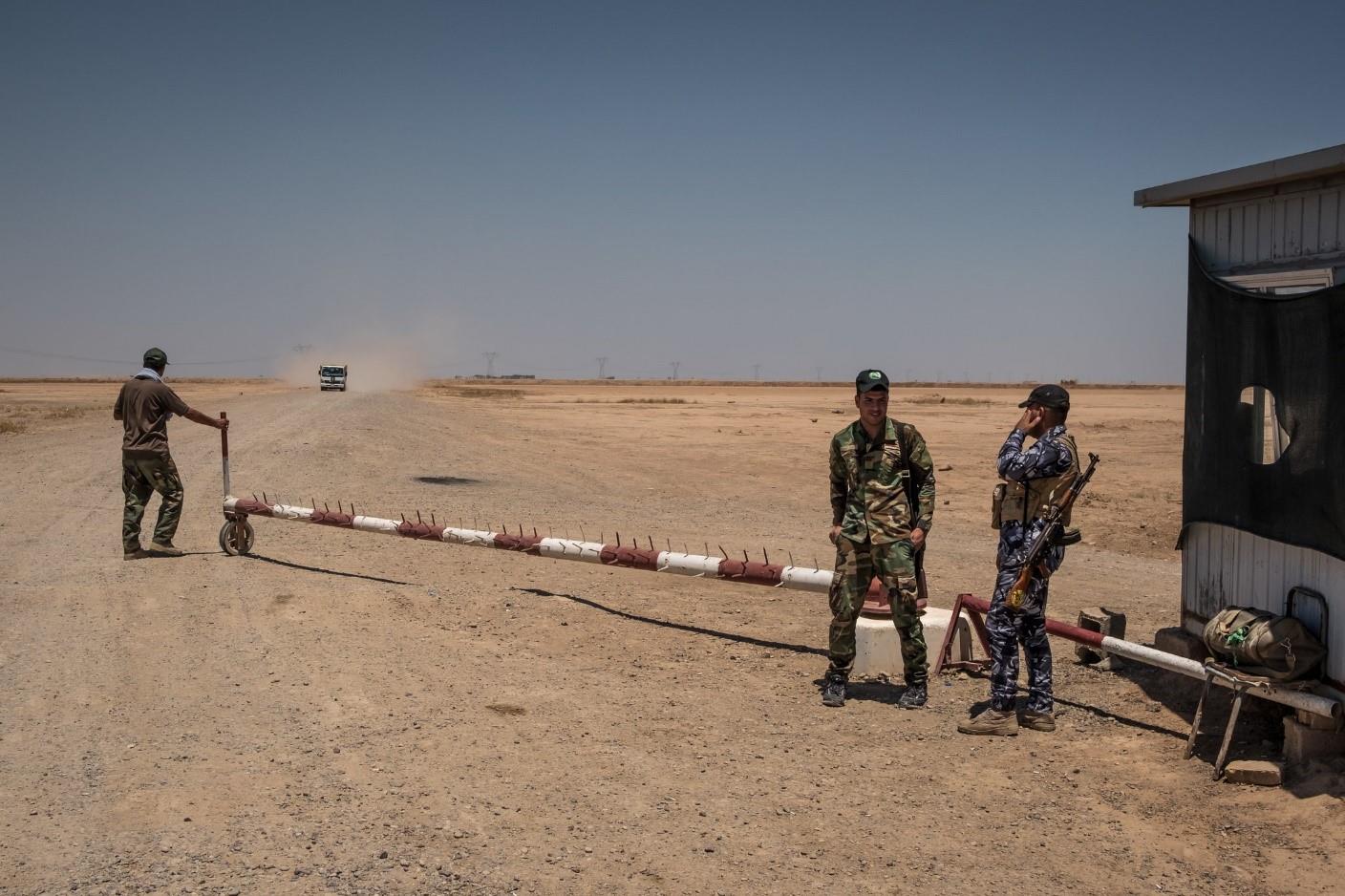  Shiite militiamen guarding the entrance to a desert road in Diyala Province that begins near the Iranian border. 