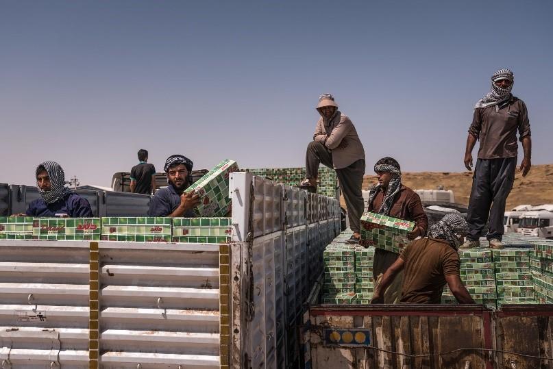  Workers unloading Iranian products at an Iraqi border crossing. The flow of goods between the two countries is one-sided. 